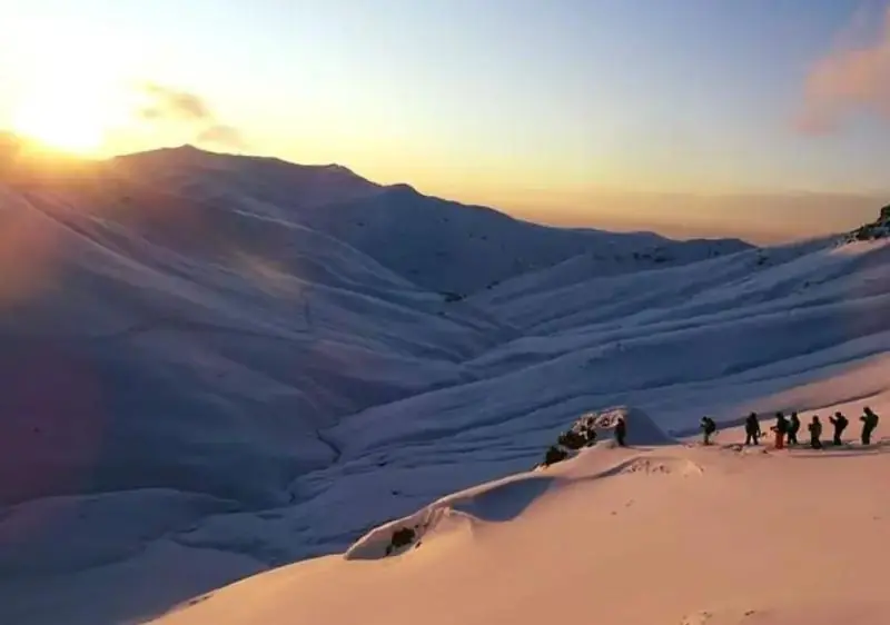 Un groupe de riders sur une crête au coucher du soleil dans le Caucase