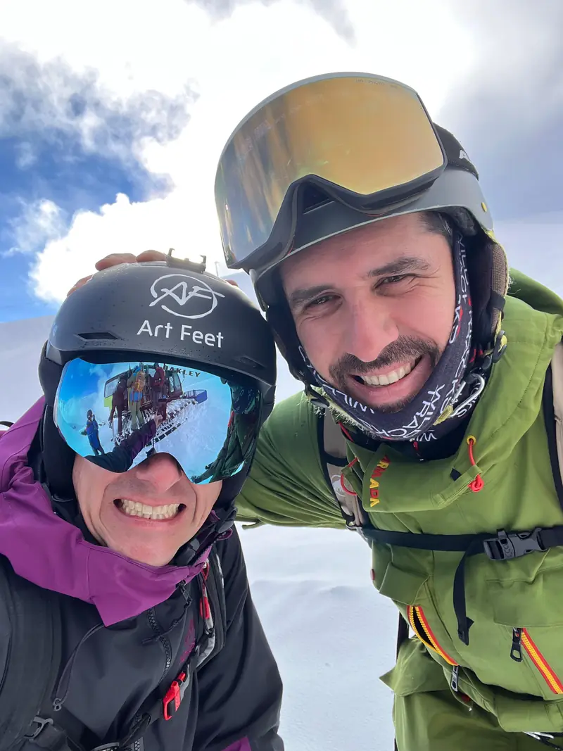Deux riders souriants, casque et masque, en montagne
