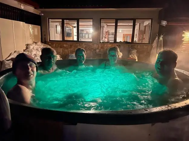 Guests relaxing in the outdoor jacuzzi in the evening