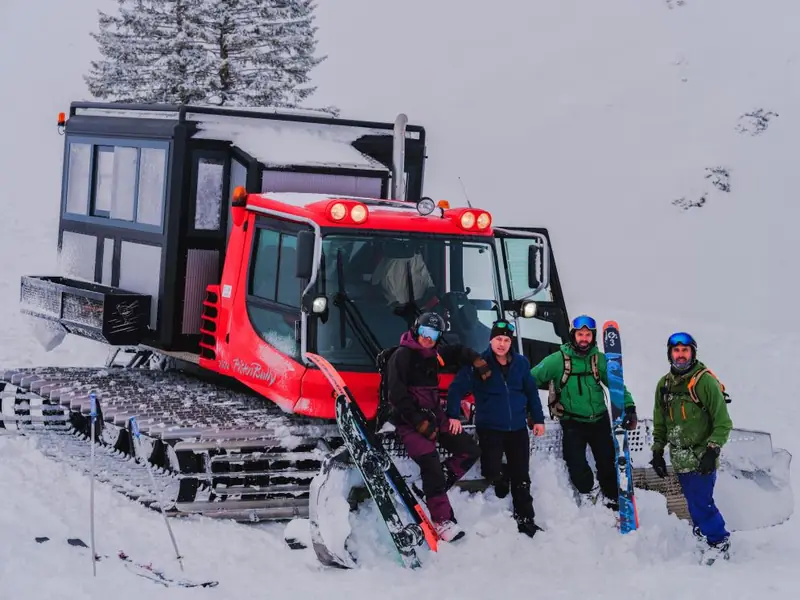Un groupe de riders devant le snowcat rouge d'Organix