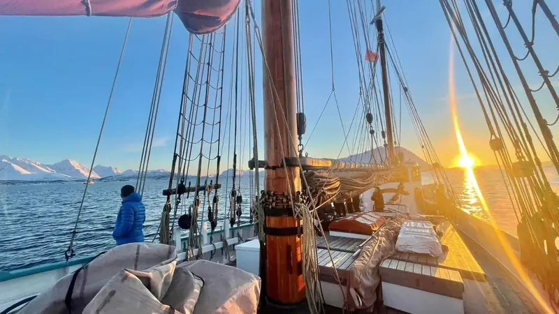 Goldenes Licht auf Deck und Takelage eines Segelschiffs in Norwegen