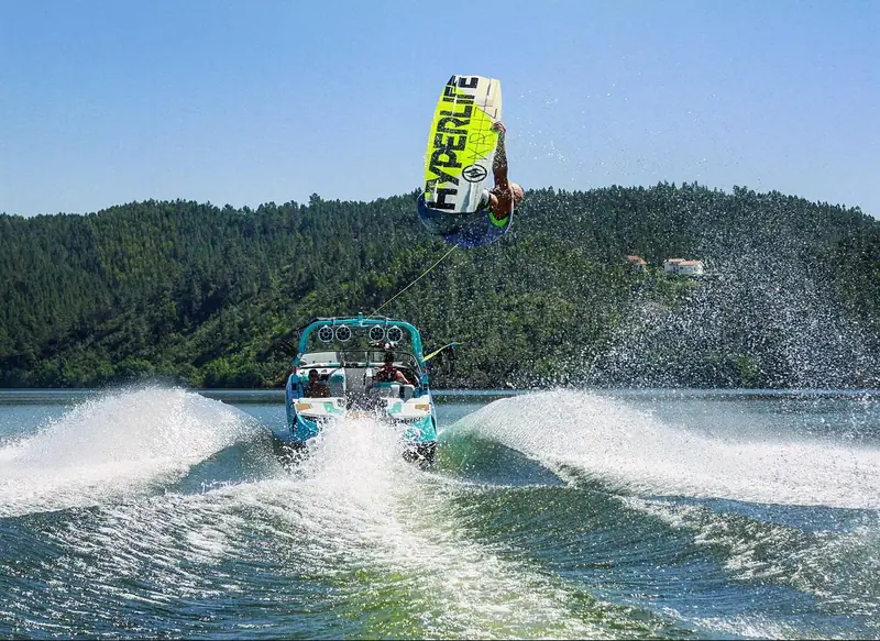 Un wakeboardeur sautant haut au-dessus du sillage du bateau