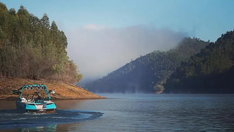A wake boat on the lake in soft morning mist