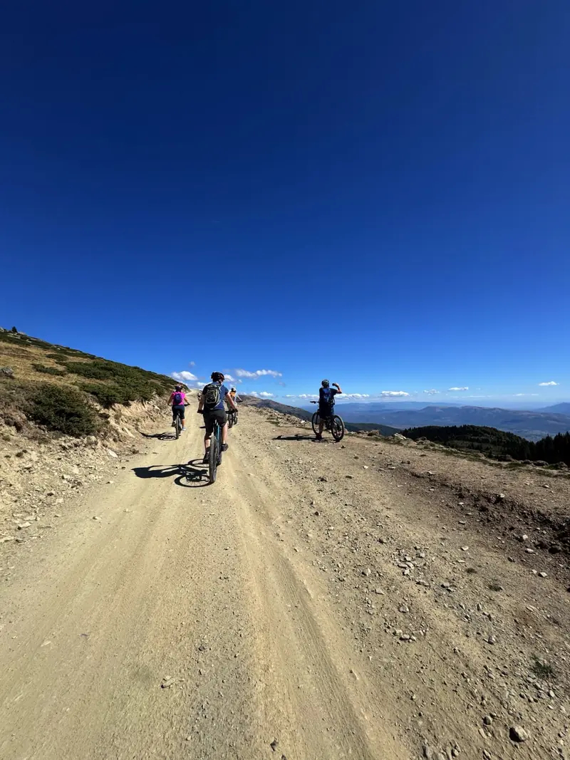 Des vététistes sur une piste de gravier à travers des collines dégagées