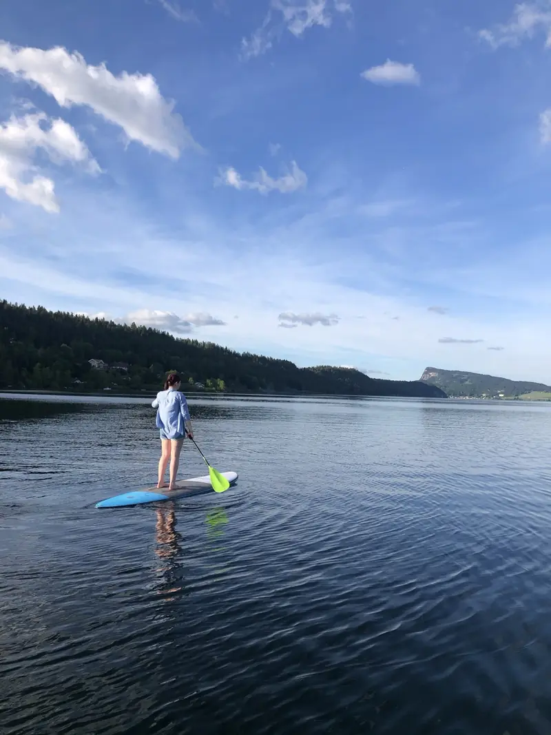 Une jeune pagayeuse sur un stand-up paddle sur un lac calme
